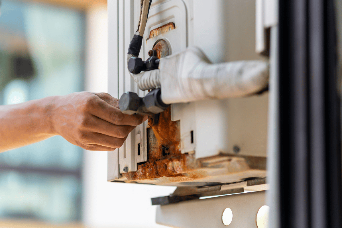 person checking pipes on electric hot water system