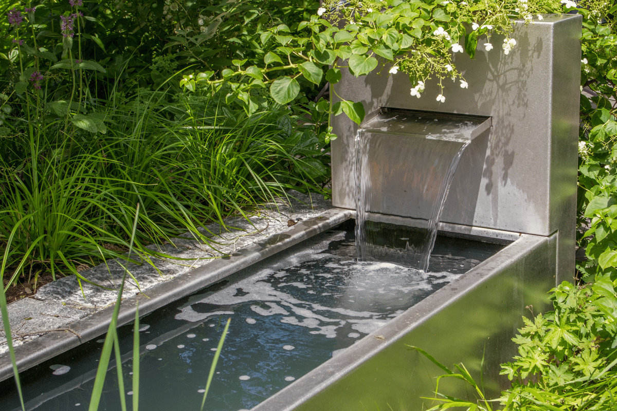 water feature with lush greenery around it