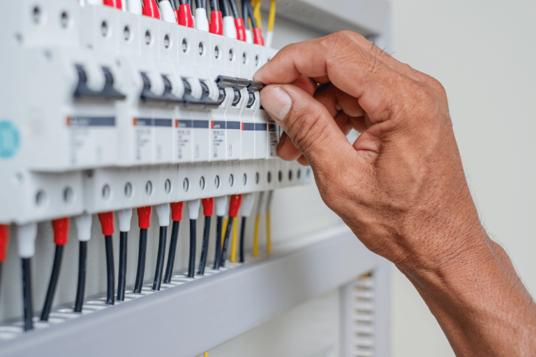 person flicking switch on breaker