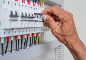 person flicking switch on breaker